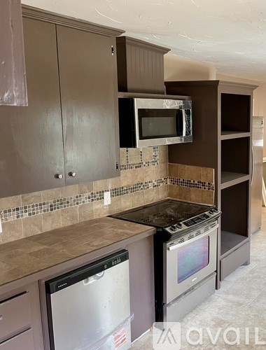 A kitchen with brown cabinets and a tiled backsplash.