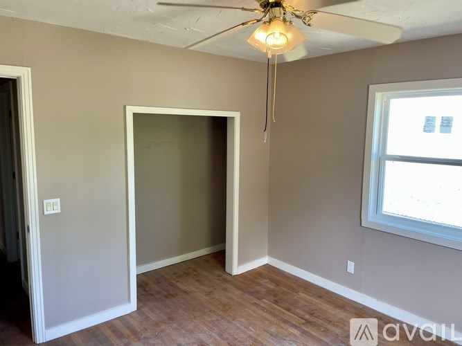A room with a ceiling fan and a window.