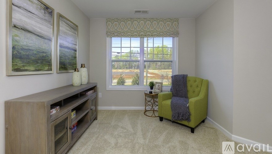 A living room with a green chair and a wooden entertainment center.