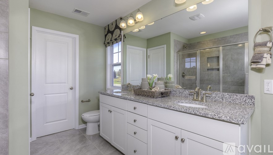 A bathroom with a granite countertop and a large mirror.