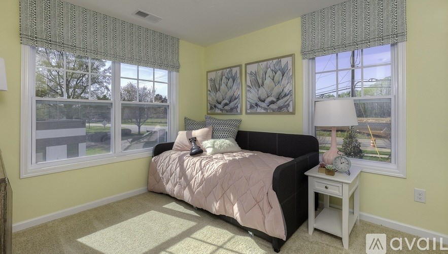 A bedroom with a bed, nightstand, and window.