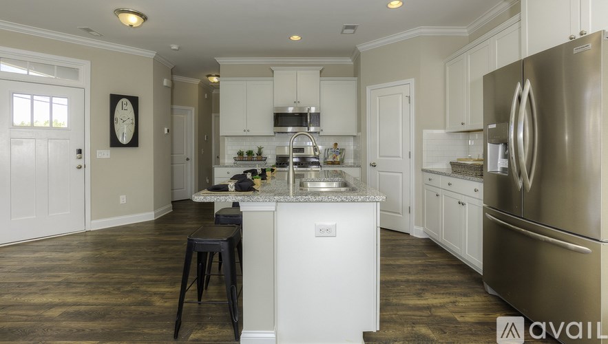 A kitchen with a white island and stainless steel appliances.