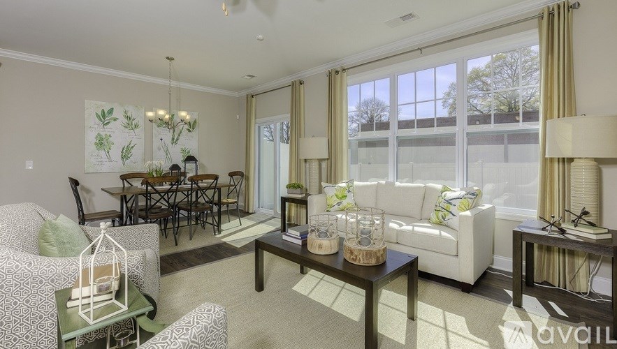 A living room with a couch, chairs, and a coffee table.