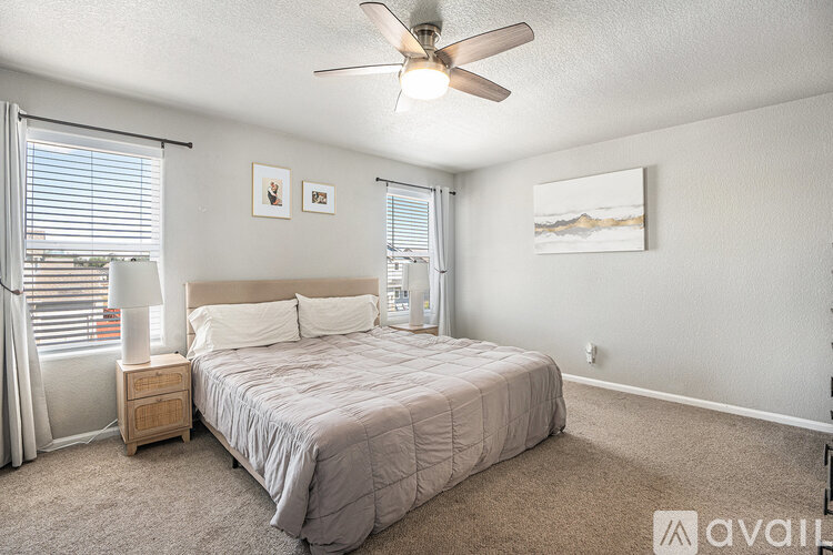 A bedroom with a bed, nightstand, and a ceiling fan.