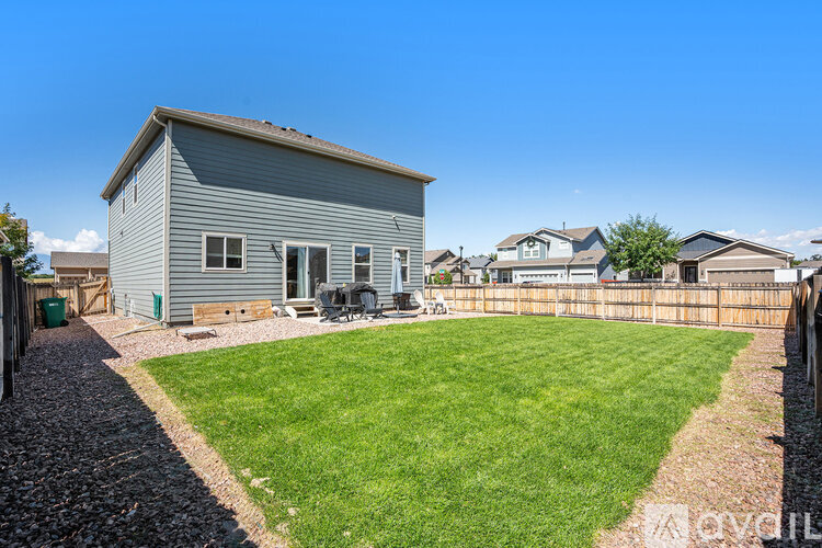 A house with a grey exterior and a green lawn.
