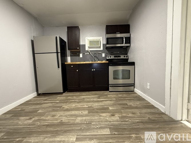 A kitchen with a refrigerator, oven, and microwave.