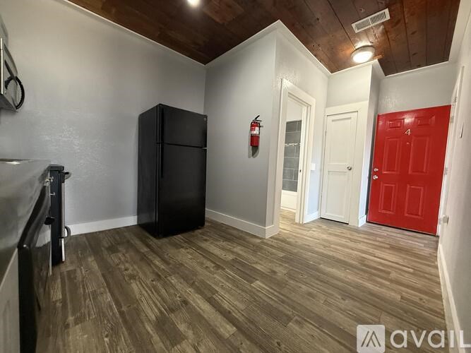 A room with wooden floors and two windows.