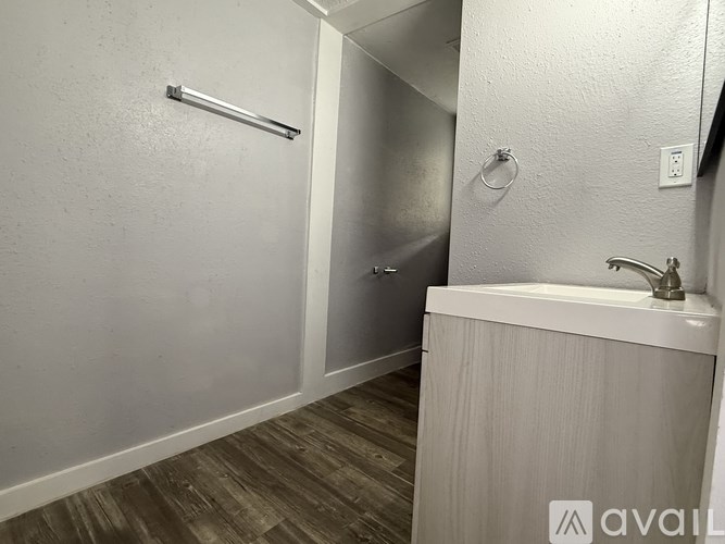 A bathroom with a white sink and a towel bar.