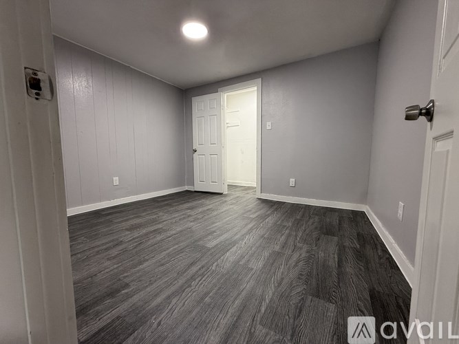 A room with a wooden floor and a white door.