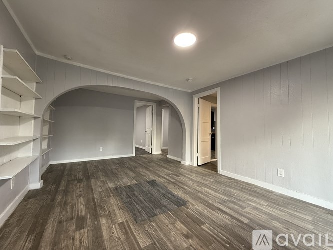 A room with wooden flooring and white walls.