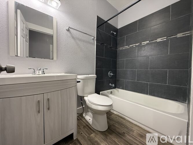 A bathroom with a white toilet, sink, and bathtub.