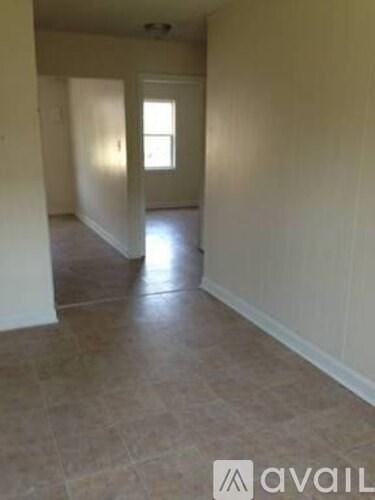 A room with tiled flooring and a window.