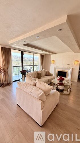 A living room with a white couch and a fireplace.