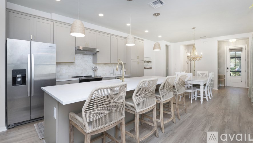 A modern kitchen with a large island and chairs.