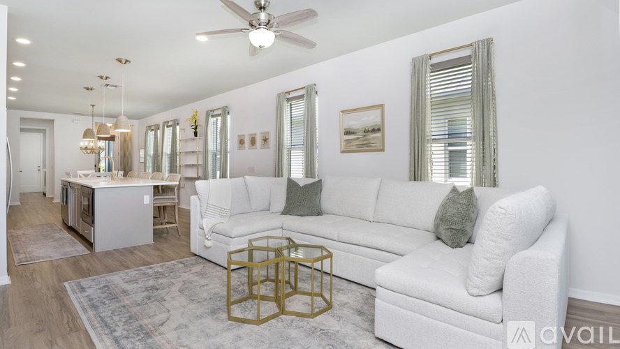 A living room with a white couch and a rug.
