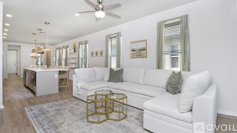 A living room with a white couch and a rug.