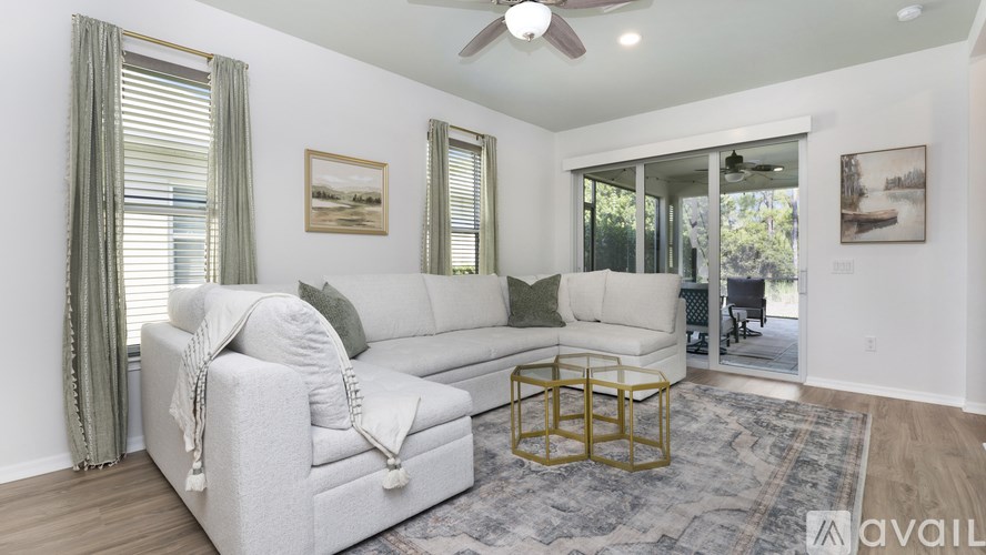 A living room with a white couch and a gold coffee table.