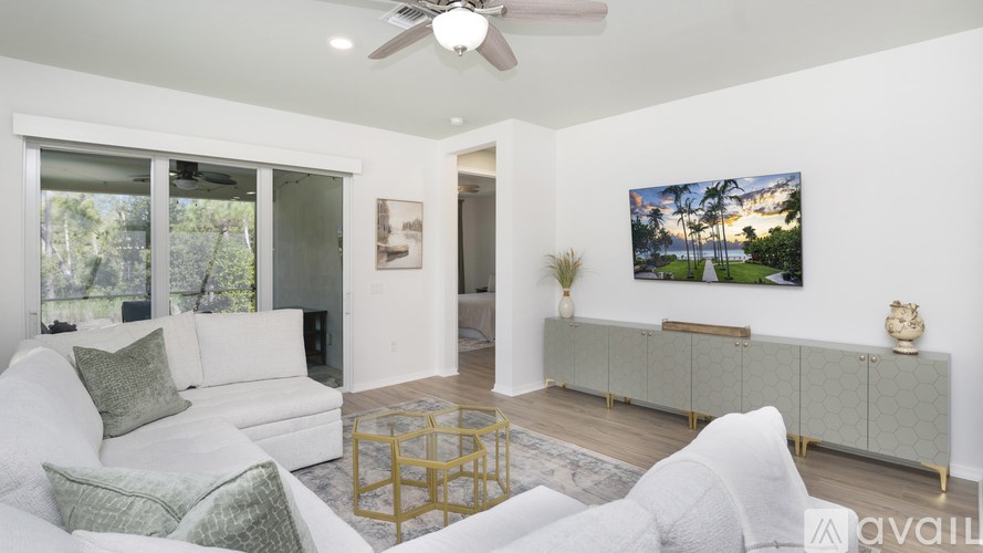 A living room with a white couch and a ceiling fan.