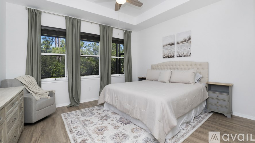 A bedroom with a large bed, a chair, and a rug.