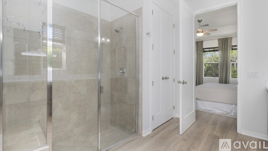 A bathroom with a glass shower stall and white walls.