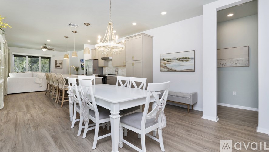 A dining room with a white table and chairs.