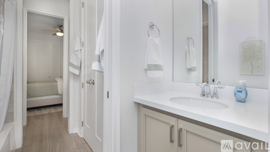 A bathroom with a white sink and a mirror.