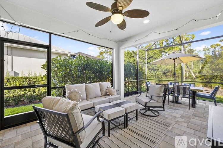 A patio with a white ceiling fan and a table with chairs.