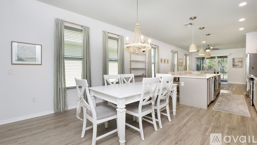 A dining room with a white table and chairs.