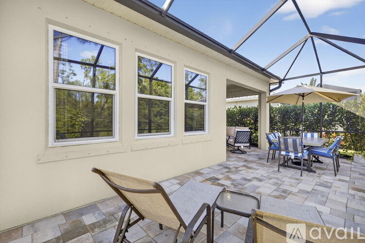 A sunroom with a glass roof, patio furniture, and a table.