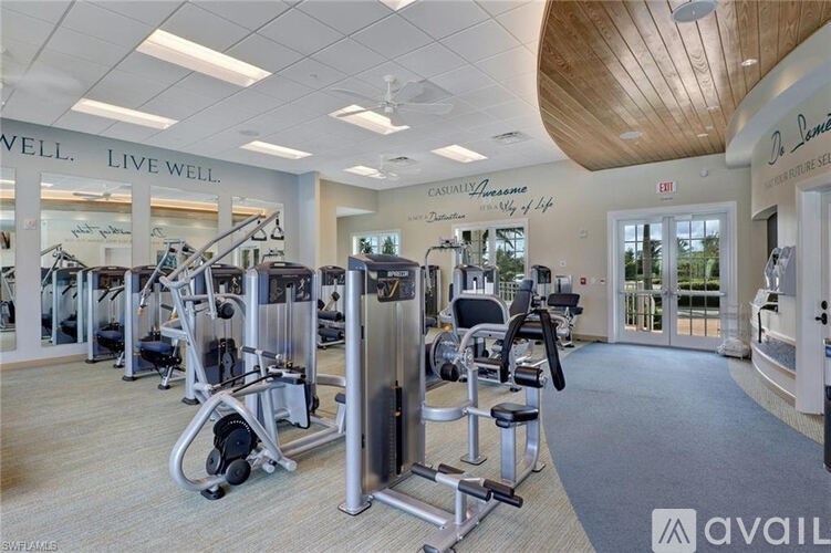 A gym with a variety of equipment including treadmills, weights, and exercise machines.