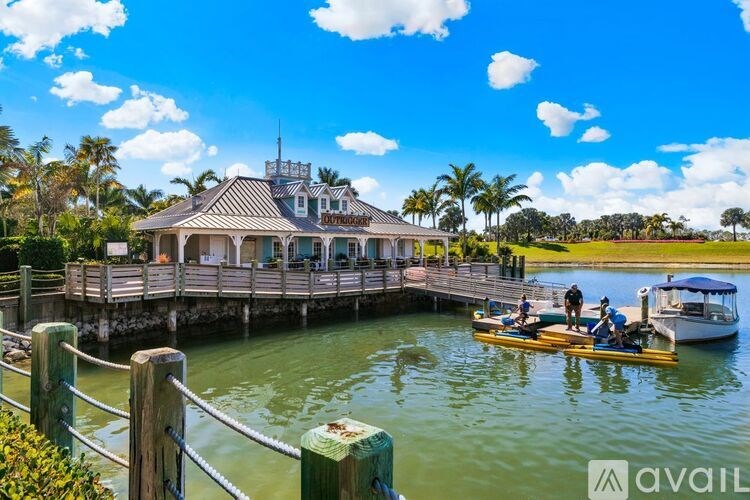 A house is built over a dock with a boat and people on it.