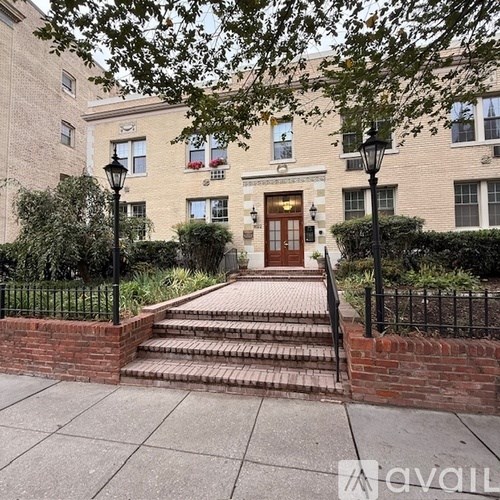 A building with a brick wall and a set of stairs leading to the entrance.