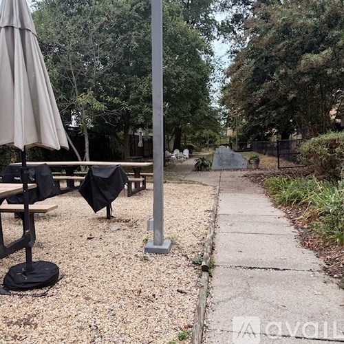 A patio area with a table and chairs and umbrellas.