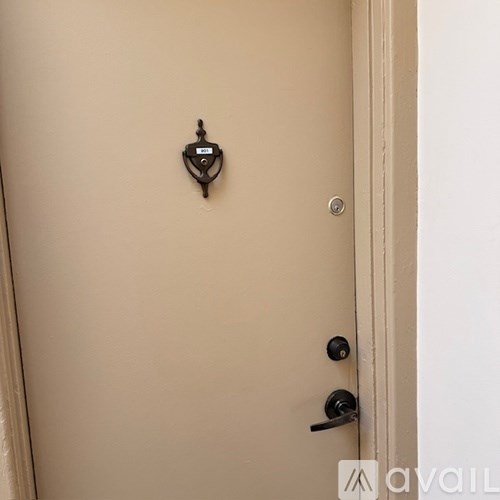 A black door handle is on a beige door.