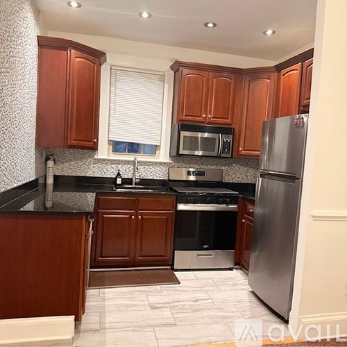 A kitchen with wooden cabinets and a black counter top.