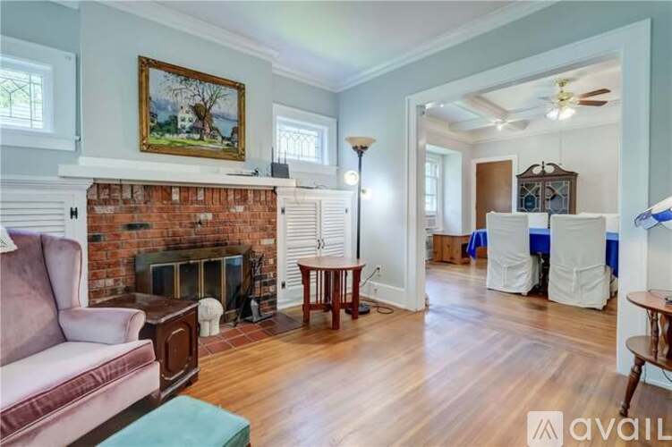 A living room with a fireplace and a painting on the wall.