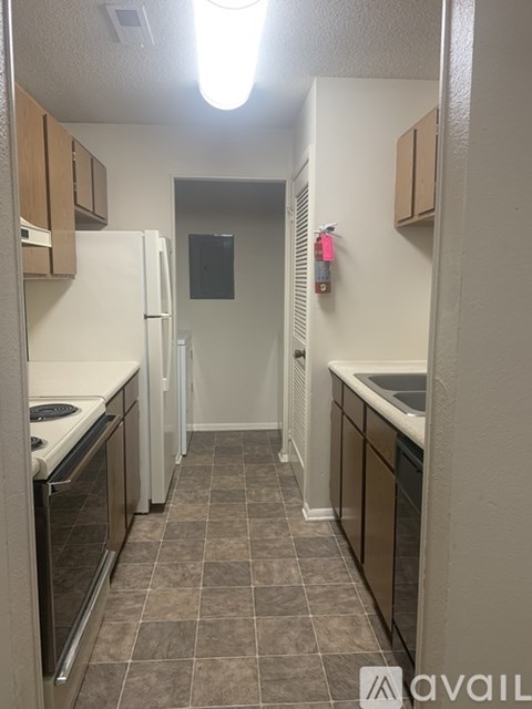 A kitchen with white appliances and brown cabinets.