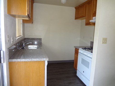 A kitchen with a white stove and a sink.