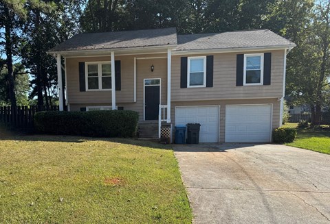 A house with a grey roof and a white garage door.