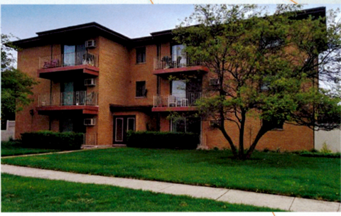 A brown building with a tree in front of it.