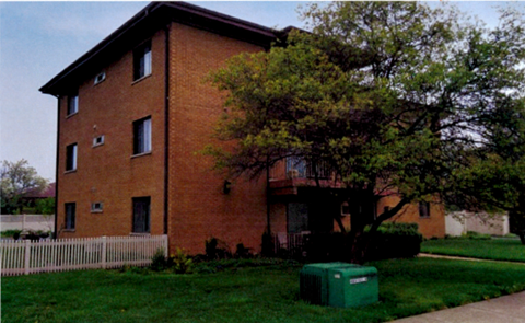 A brown building with a green box in front of it.