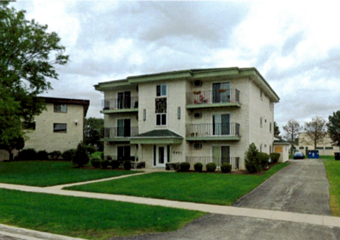 Apartment building with a green lawn in front.