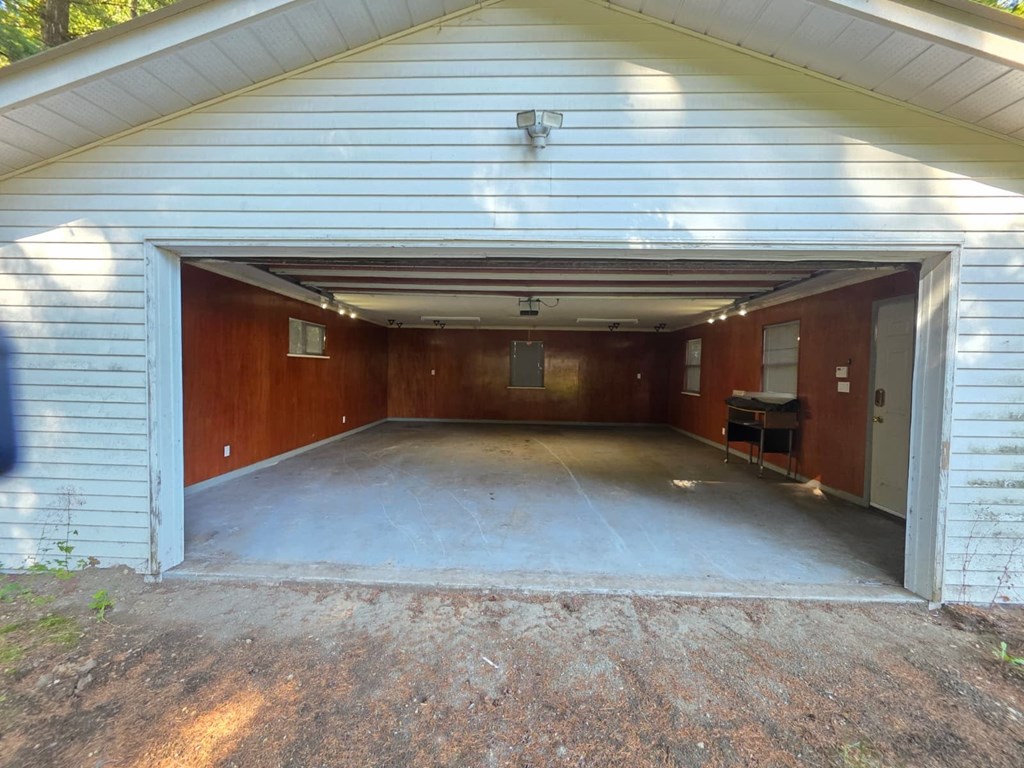 A garage with a white siding and a brown door is shown.