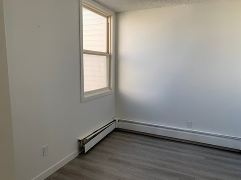 A room with a window and a radiator on the wall.