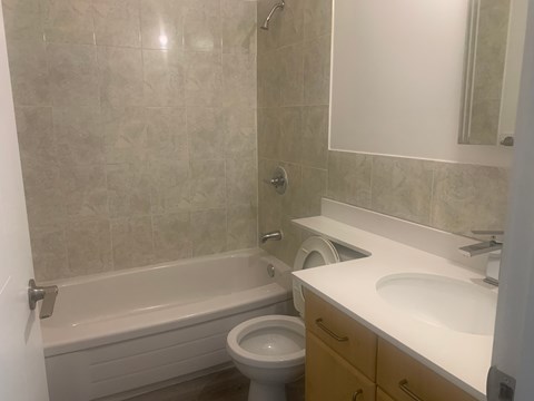 A bathroom with a toilet, sink, and bathtub.