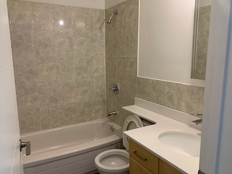 A bathroom with a tub, toilet, and sink.