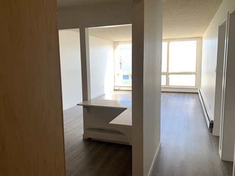 A long hallway with a kitchen area at the end.