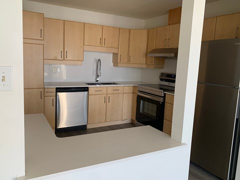 A kitchen with wooden cabinets and stainless steel appliances.