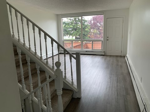 A staircase with a white railing leads to a door.