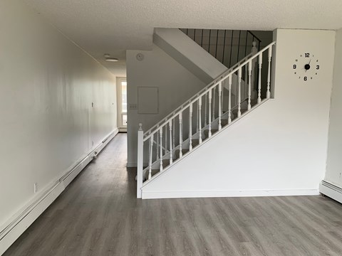 A white wall with a clock showing the time 12:00.